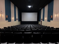 an empty theater with rows of seats and a projection screen