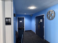 a hallway with blue walls and a trash can