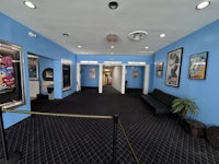 the lobby of a movie theater with posters on the walls