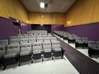 a theater with rows of seats and purple walls